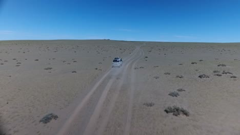 Luftdrohnenaufnahme,-Die-Einem-Lieferwagen-In-Der-Wüste-Der-Mongolei-Folgt